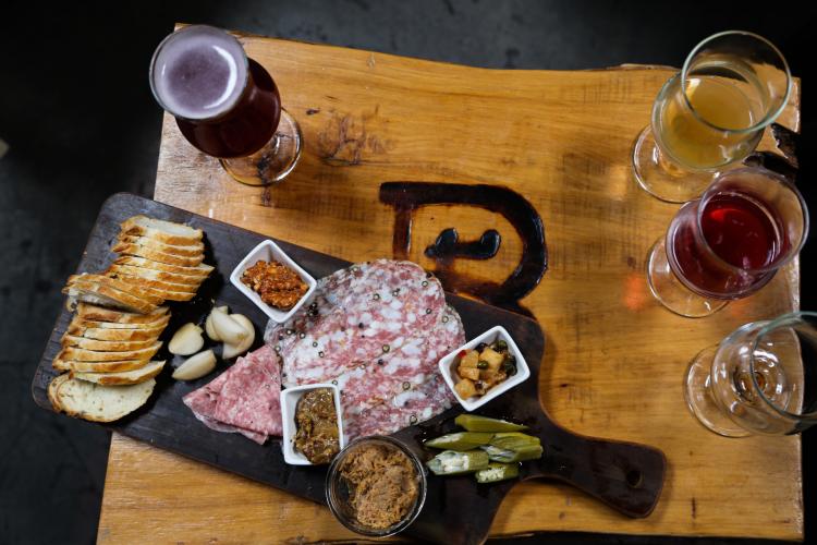overhead view of Rare Barrel Charcuterie board and four craft beers