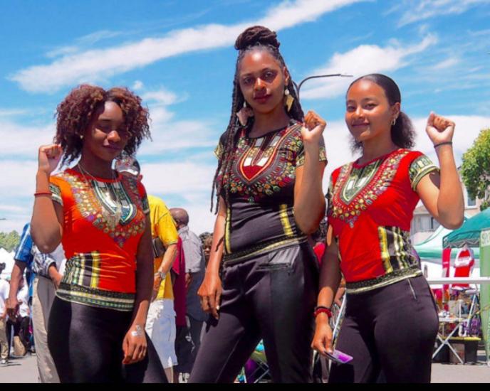 Three women posing for a photo at the Berkeley Juneteenth Festival in California