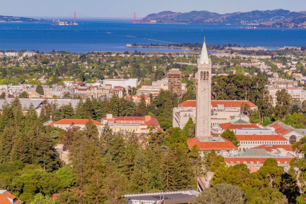 aerial view of the Berkeley skyline featuring red roof buildings and a clock tower with the bay in the distance