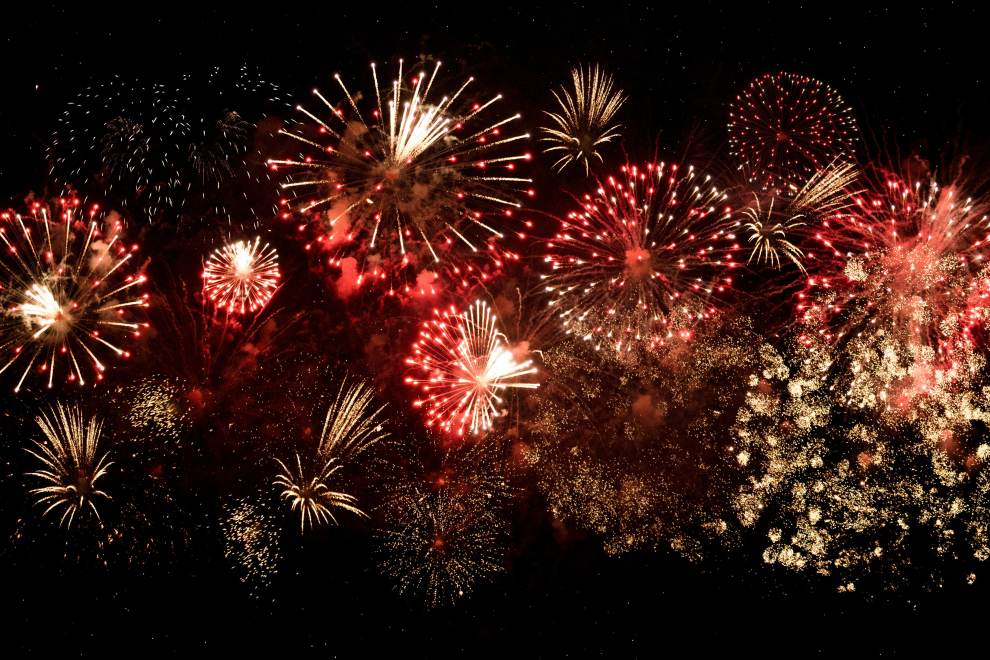 A  fireworks display illuminates the night sky.
