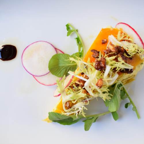 top-down close-up of an expertly crafted plate of vibrant produce at a fine dining restaurant in Berkeley