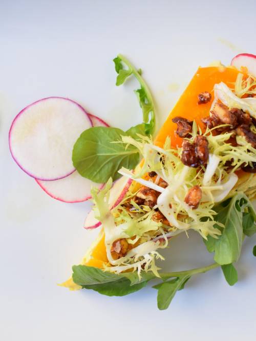 top-down close-up of an expertly crafted plate of vibrant produce at a fine dining restaurant in Berkeley