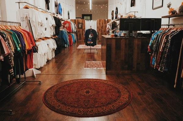interior of Paisley Vintage, a Berkeley thrift store, with neatly organized clothing lining both sides of the store