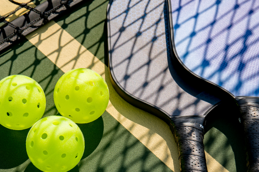 close up of pickleball balls and paddles