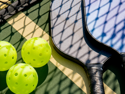 close up of pickleball balls and paddles