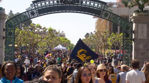 Students walk on a walkway beneath an arch at University of California Berkeley in Berkeley, CA