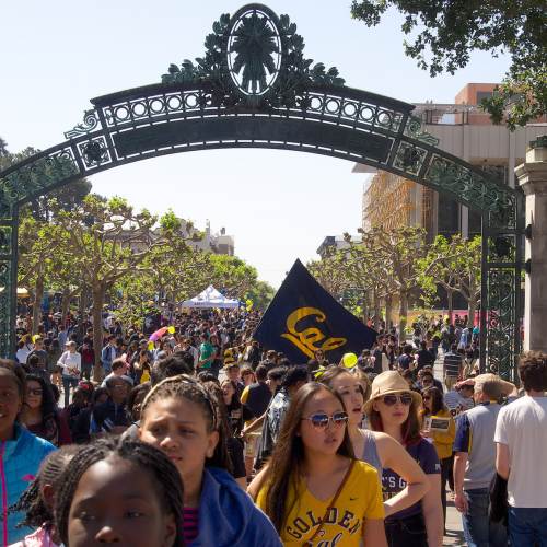 Students walk on a walkway beneath an arch at University of California Berkeley in Berkeley, CA