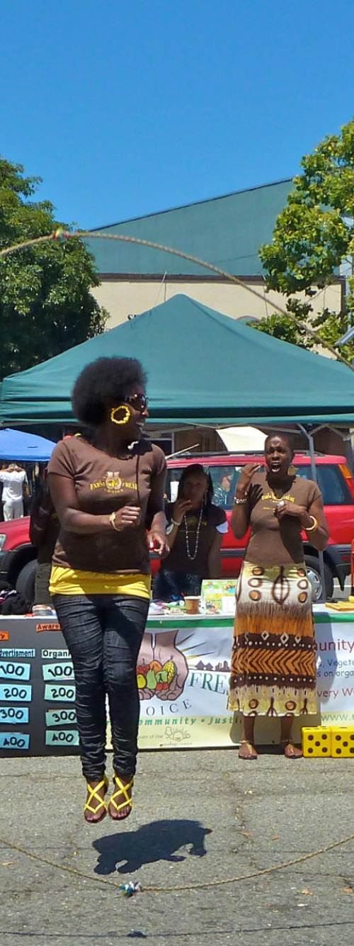 One person jumps rope as two others hold each end of the rope at a festival in Downtown Berkeley, CA.