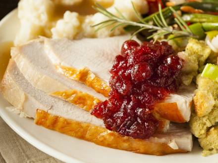 Close up of a plate of sliced turkey, cranberry sauce, stuffing and mashed potatoes. credit @skatesonthebaysf